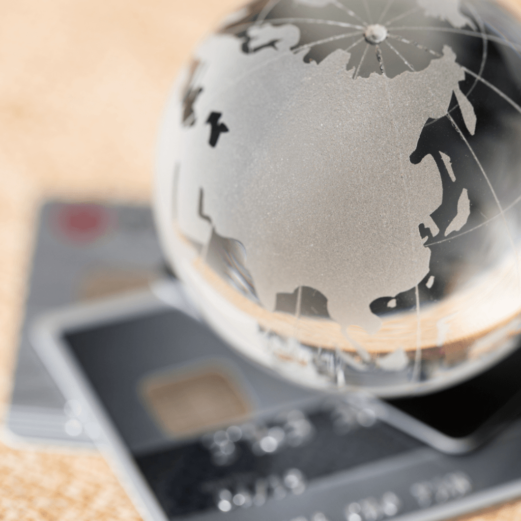 Transparent globe resting on credit cards, symbolizing global financial transactions and transfer pricing cases