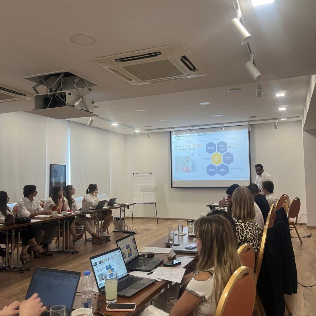 Business professionals in a conference room attending a presentation on cross-border tax and transfer pricing strategies.