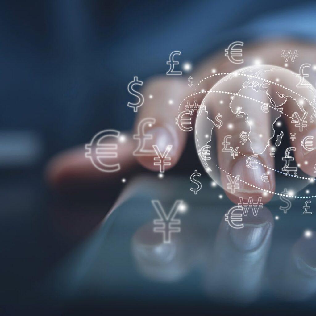 Close-up of a hand using a smartphone with digital global currency symbols, including dollar, euro, pound, and yen, representing transfer pricing trends and international finance